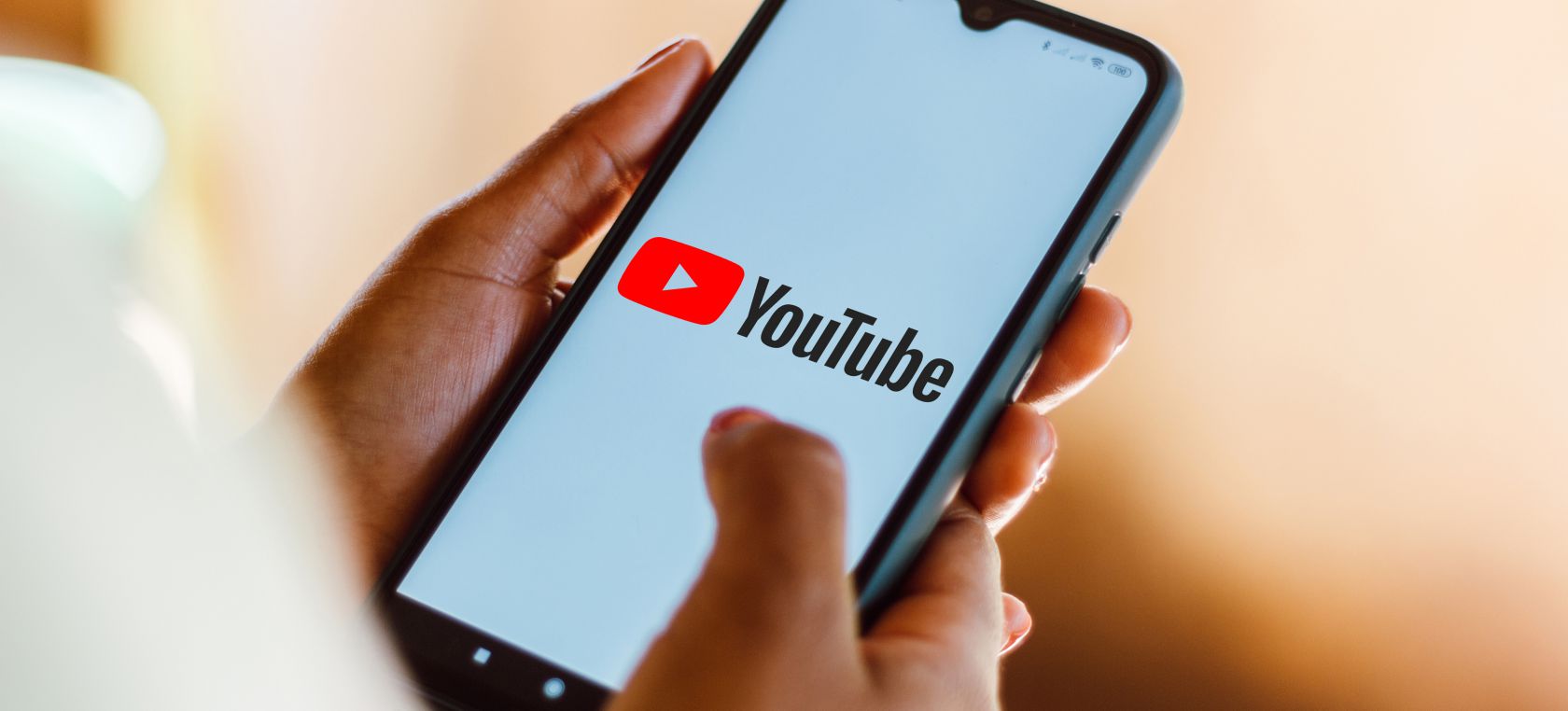 Unas manos sujetan un móvil con el logo de Youtube Unas manos sujetan un móvil con el logo de Youtube