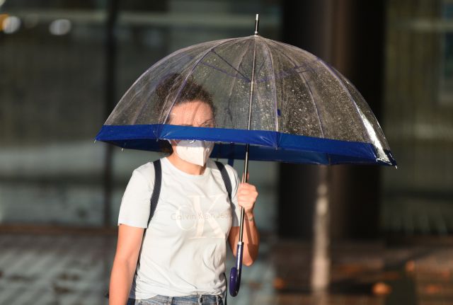 Chica con mascarilla bajo un paraguas